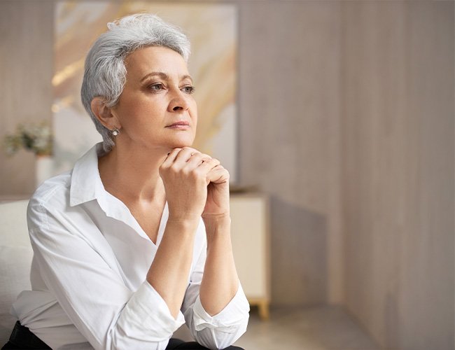 Mulher na fase da menopausa com expressão tranquila, representando alívio e equilíbrio após tratamento hormonal com endocrinologista